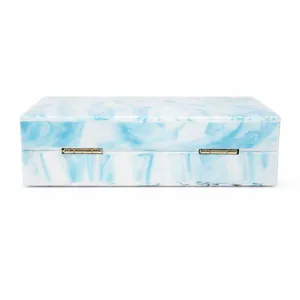 Detail view of gold hinges on blue marble acrylic evening clutch bag with premium texture