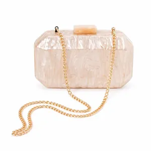 Detail view of octagon marble acrylic evening clutch with gold chain strap on white background