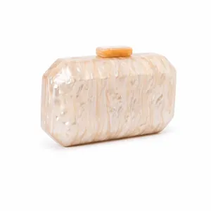 Macro detail of octagonal acrylic evening clutch with marble texture and golden hardware