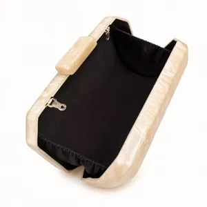 Detail view of open marble acrylic evening bag with metal clasp and black interior lining