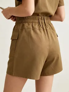 Detail of khaki high-waisted utility shorts with elastic waist and cargo side pocket