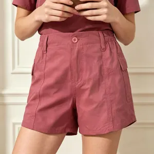 Detail of rose pink denim utility shorts featuring flap pockets and high-waist stitching