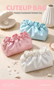 Detail of pleated pearlescent makeup bags in blue, pink, and white with pearl zippers