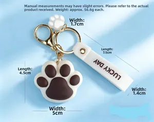 Detail of cute cat paw keychain with white silicone strap and golden metal lobster clasp