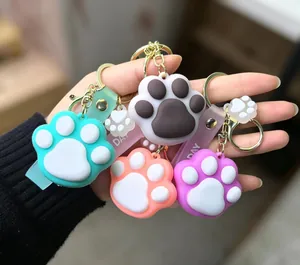 Close-up of colorful cat paw keychains held in hand with silicone straps and gold rings
