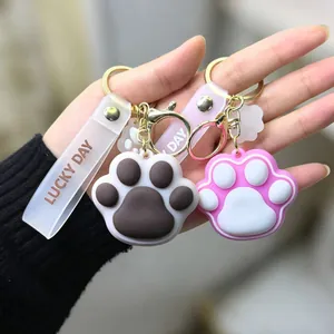 Close-up of cute cat paw keychains in pink and brown with Lucky Day wrist straps