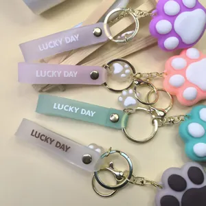 Detailed close-up of macaron cat paw keychains with Lucky Day wrist straps and metal rings