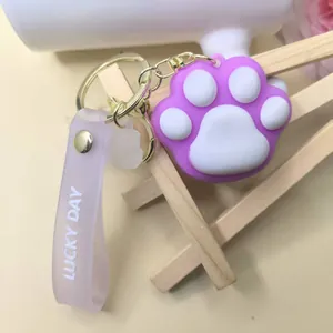 Detail of purple silicone cat paw keychain with Lucky Day strap and gold clasp