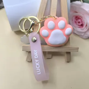 Detailed shot of pink cat paw keychain with Lucky Day wrist strap and gold metal clasp