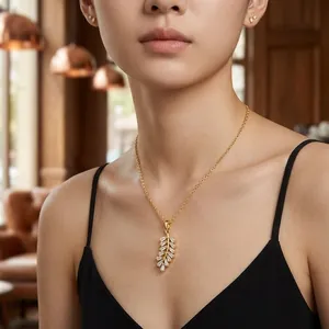 Elegante set di collana con pendente a piuma dorata e orecchini con pietre di zircone