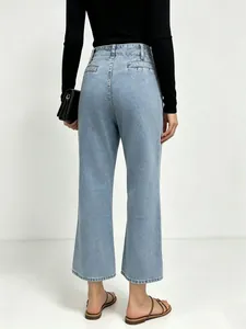 Detail view of high-waist light blue denim jeans with back seams and straight leg fit