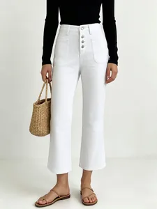 Detail of high-waisted white wide-leg jeans featuring a four-button fly and patch pockets