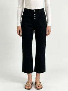 Detail of high waisted black denim jeans featuring a four-button fly and retro large pockets