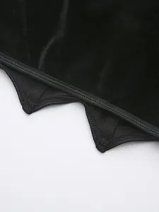 Détail macro d'un top corset en velours noir montrant l'ourlet zigzag et les baleines