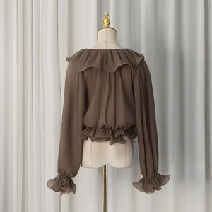 Detail of coffee brown ruffled chiffon blouse with pleated texture and elastic waist
