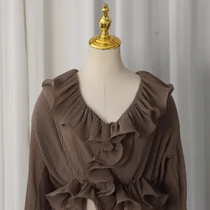 Detail of coffee brown pleated blouse featuring elegant ruffles and a classic V-neckline