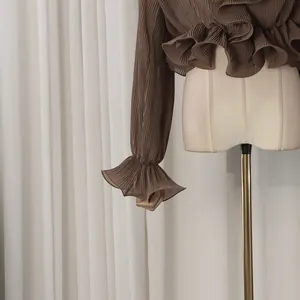 Detail of coffee brown pleated blouse with ruffled cuffs and collar in vintage style