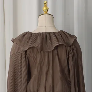 Detail view of the elegant deep brown pleated blouse with layered ruffles on the back