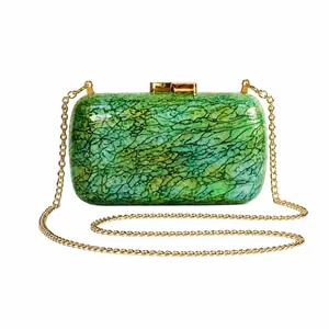 Close-up of green marble acrylic clutch bag with gold clasp and chain strap