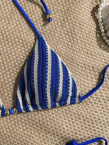 Close-up of crochet bikini top with blue stripes and decorative bead details