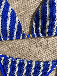 Detail of blue striped crochet bikini set featuring a beaded center and knit texture