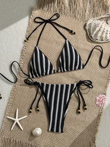 Flat lay of black and white striped knit bikini with side ties and seashell decor