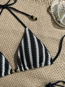 Detail of crochet bikini top with black white stripes and golden bead accents
