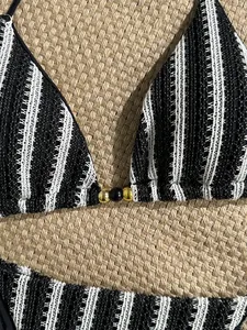 Detail of knit striped bikini top featuring textured fabric and decorative gold beads