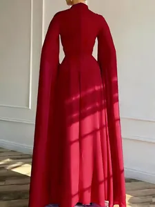 Close-up of elegant dark red evening dress with high collar and cape sleeves detail