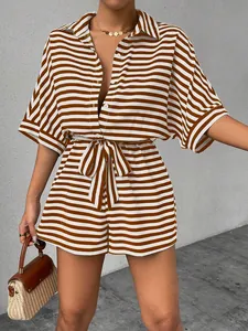 Detail of striped short romper with collar buttons and waist tie on a model
