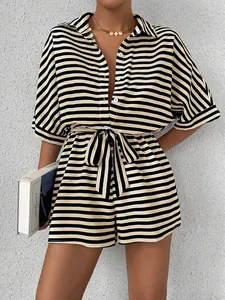 Detail of striped short romper with button closure and matching waist belt for summer wear