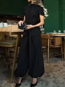 Detail of elegant black two-piece suit featuring stand collar top and wide-leg trousers