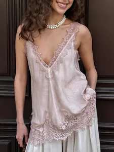 Detail of V-neck satin camisole with champagne lace trim and eyelash fringe edges