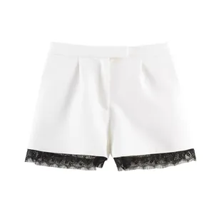 White high-waisted shorts with elegant black floral lace trim and pleated front details