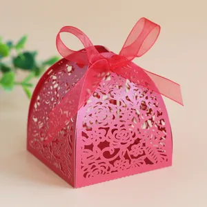 Detail of red laser-cut floral candy box with pearlescent finish and ribbon bow