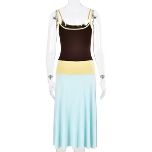 Detail of color-block maxi dress with brown top, yellow waist, and light blue skirt