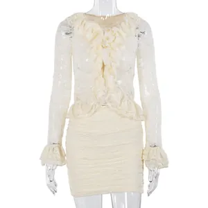 Macro detail of creamy lace top with ruffled edges, pearl buttons and matching mini skirt