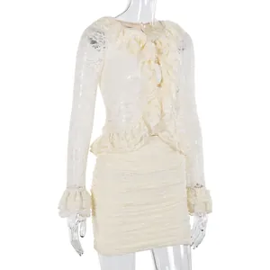 Close-up of cream lace top and skirt set with pearl buttons and ruffled cuffs