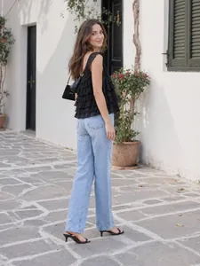 Top chic en dentelle noire à volants porté avec un jean large bleu clair à taille haute