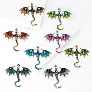 Enamel dragon brooches set with rhinestones in multiple colors on white background