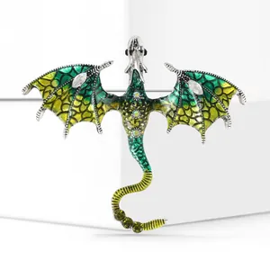 Macro shot of alloy dragon brooch with green-yellow enamel coating and blue rhinestones