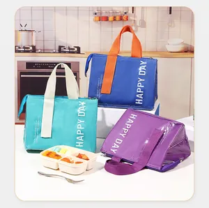 Close-up of insulated lunch bags in blue, green, and purple with Happy Day lettering