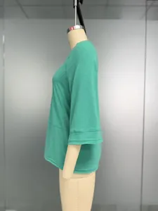 Detail der grünen Raglan-Glockenärmel und Doppelnaht am lässigen Strickoberteil für Damen