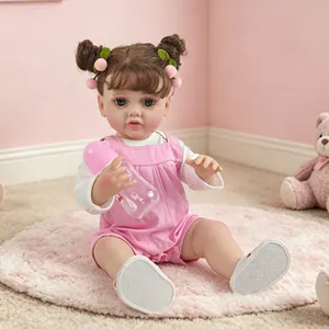 Detailed view of a 55cm realistic reborn doll with double buns holding a pink baby bottle