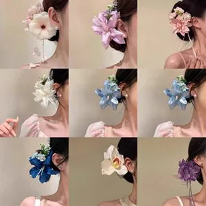 Detail van grote stoffen bloem haarklemmen in negen kleuren met parelmoer hart