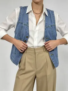 Détail du gilet en jean bleu clair avec boutons vintage et coutures texturées élégantes