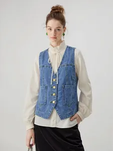 Détail du gilet en jean bleu vintage avec boutons en cuivre et grandes poches pratiques