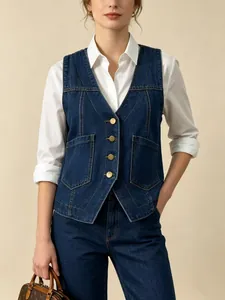 Détail d'un gilet en jean bleu ajusté avec boutons dorés et coutures contrastées élégantes