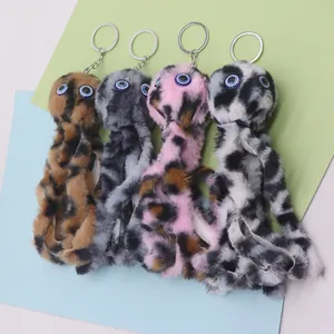 Detail view of colorful faux fur monster keychains with large blue eyes and metal rings