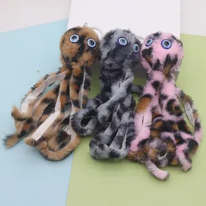 Close-up of leopard print plush octopus keychains with blue devil eye details